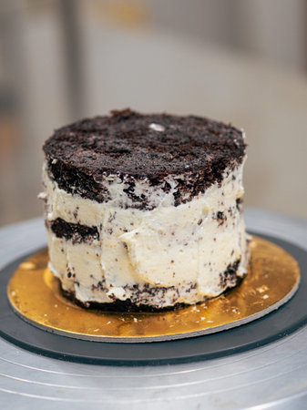 professional baker decorating a chocolate and cream cake with salty caramel