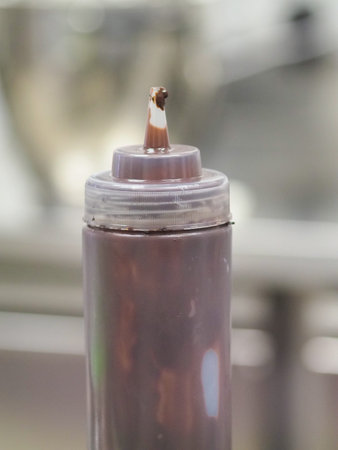 tools of the cake designer - squeezing bottle with chocolate filling for frosted cake drippingの写真素材