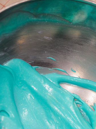 melting piping bag light blue turquoise green filling to drip a frosted cake