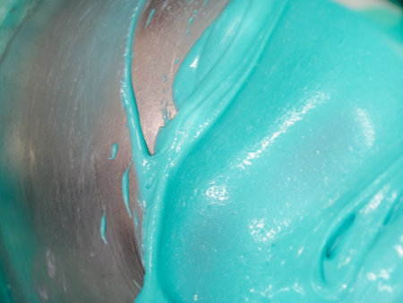 melting piping bag light blue turquoise green filling to drip a frosted cakeの写真素材