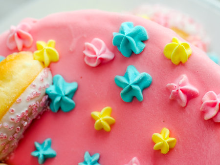 Close up of pink frosted dripping cake with donut and plastel brushed royal star sprinkles insolated on white studio shotの写真素材