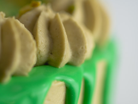 studio shot of green pistachio frosted dripped icing cup cakeの写真素材