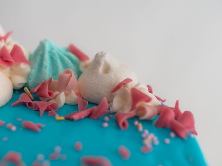studio shot of chocolate frosted blue dripped icing white cup cake, unicorn , meringue and sprinkles...