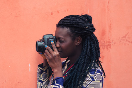 Portrait of an woman with dreadlocks smiling while making a photograph with reflex camera.の写真素材