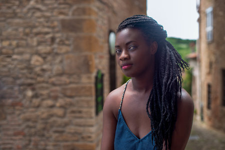 Happy young black woman smile. Stylish model. Braided dreadlocks hairstyle. Joyful smiley African female in selective focus outdoors, fashion style, happiness concept. Outdoors.の写真素材