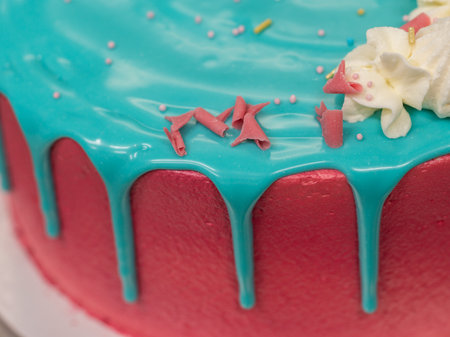 preparing frosted pink blue cup cake with meringue, sweet sprinkles and unicorn toppingの写真素材