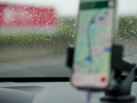 5g Smartphone displaying GPS navigation mounted on a car's dashboard, A1 A8 near Milan, Italy