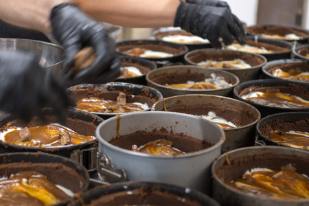 pastry chef preparing and baking a group chocolate crust for salty caramel cheesecake in...