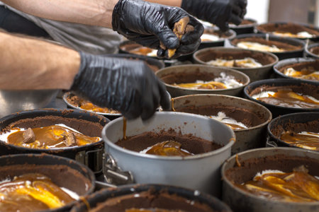 pastry chef preparing and baking a group chocolate crust for salty caramel cheesecake in...