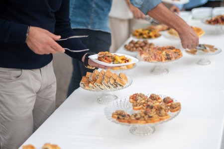 Guests gather around a beautifully arranged buffet table during a private event selecting delicious...