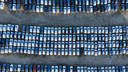 New cars filling a large outdoor parking lot in orderly rows, illustrating wholesale vehicle storage...