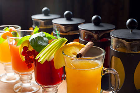 four teapots and glasses with different colors fruit tastes of teaの写真素材