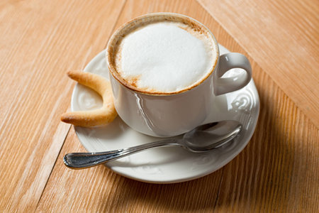 cookie and cup of coffee on wooden tableの写真素材