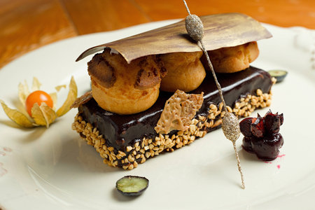 Decorated chocolate dessert on white plate