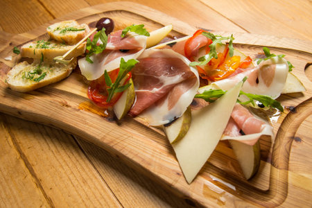 Italian prosciutto, cured pork meat on cutting boardの写真素材