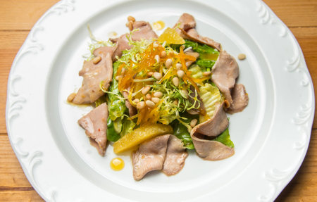 Warm salad with beef and sesame seeds on white plateの写真素材
