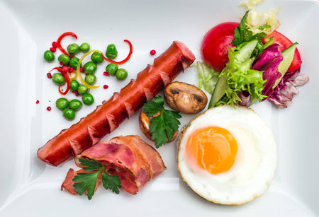 fried eggs with  bacon, sausages and toastsの写真素材