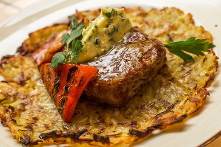 Grilled New York strip steak with bearnaise sauce, potato wedges, and cherry truss tomatoesの写真素材