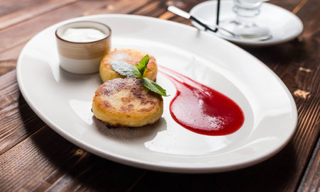 Fried fritters on plate with sour creamの写真素材