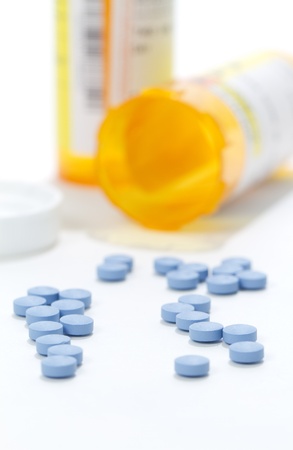 Medicine Bottle Spilled   A macro shot of a medicine bottle on its side with pills spilled out  Cap and 2 orange bottle present  focus on pills の写真素材