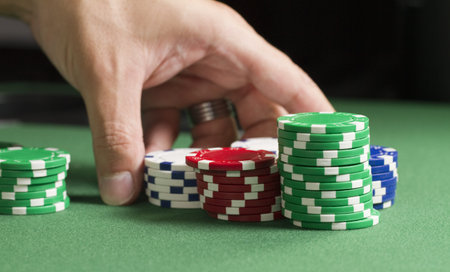 a macro shot of a gambler rearranging poker chips on a felt table  shallow depth of field