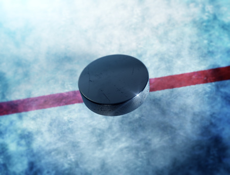 Hockey puck above the ice and red line with lens flare around puck.の写真素材