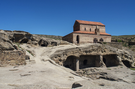 Cave town Uplistsikhe, Georgia. Stone buildings and a monastery in the background of the mountainsの写真素材