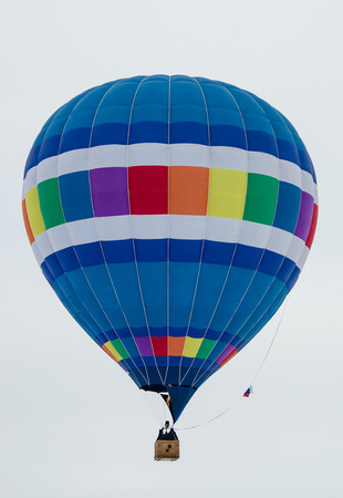 multicolored striped balloon on a light gray sky backgroundの写真素材