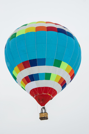 multicolored striped balloon on a light gray sky backgroundの写真素材