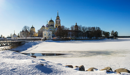 Monastery Nile Hermitage, lit by the sun. Against the backdrop of the road and the frozen Lake Seliger. Tver region, Russia.の写真素材