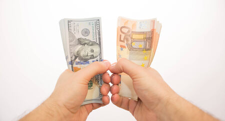 two palms handing dollars and eurosの写真素材