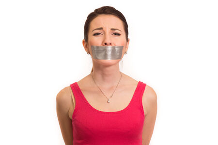 woman in red with gaffer tape on her mouth experiencing emotional pain isolatedの写真素材