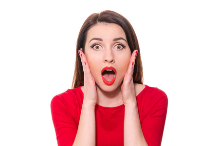 Adorable woman with red lipstick standing in awe looking at camera with mouth and eyes open wide surprised isolated on white backgroundの写真素材