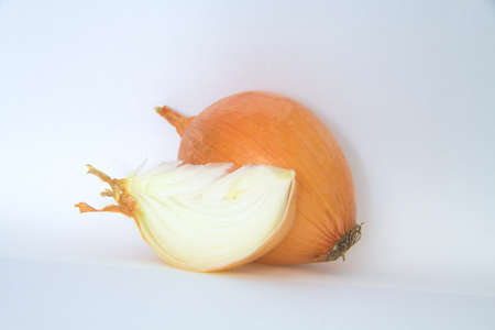 Onion with a slice isolated on whiteの写真素材