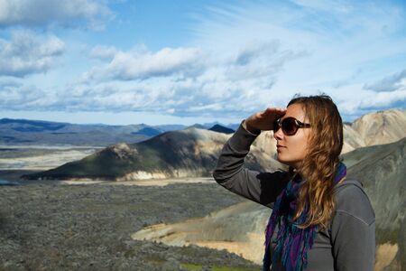Girl at the foot of the mountains looking into the distanceの写真素材