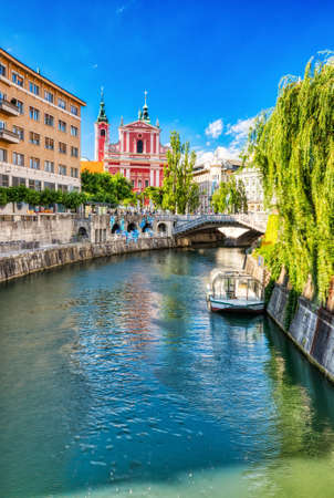 Ljubljana City Center during a Sunny Day overlooking Lublanka river and Beautiful Franciscan Church, Sloveniaの写真素材