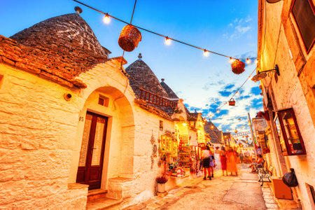 Famous Trulli Houses in Alberobello Illuminated at Dusk, Puglia, Italyの写真素材