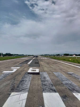 Airport runway with cloudy sky in the background. Airplane parkingの写真素材