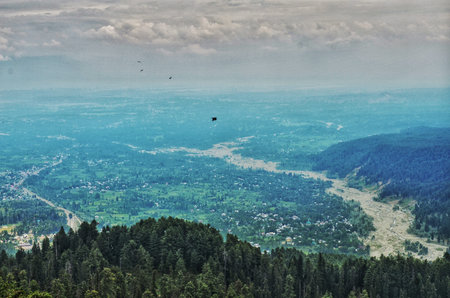 Aerial view of the valley and mountains in the clouds. Beautiful summer landscape.