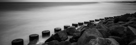 pylons and rocks on the shore keeps you safe concrete defensive blocks and ocean waves
