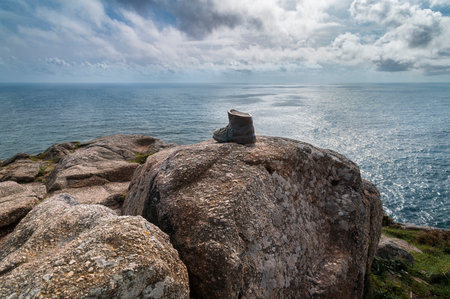 Old boot symbolizing the end of the Camino de Santiago at cape Finisterreの写真素材