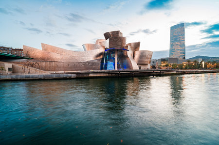Guggenheim Museum Bilbao showcasing its modern deconstructivism titanium architecture by Frank Gehry, with urban buildings and a clear skyline in the background. Bilbao Spain October 20th 2025のeditorial素材