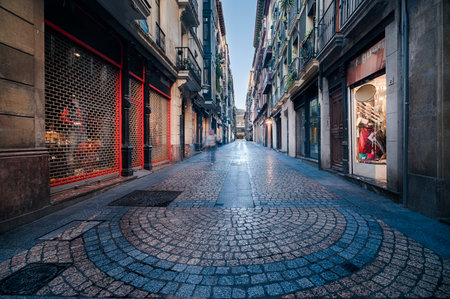 Casco Viejo, Bilbao's old town, showcasing an empty cobblestone street lined with traditional buildings and closed shopfronts, at early morning. Bilbao Spain October 20th 2025のeditorial素材