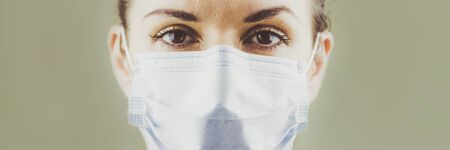 Portrait of a Female Patients Doctor in a Protective Surgical Sterile Mask. Soft focus.の写真素材