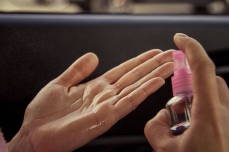 Womens palms are wet from disinfectant alcohol in the carの写真素材