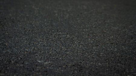 The surface of the black asphalt is a soft focus. Dark Tar Asphalt Background texture at an angle of 20 degrees.の写真素材
