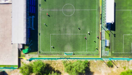 Training of football team players on the green grass of the football field of the sports base - view from aboveの写真素材