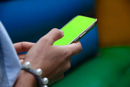 Smartphone with a screen of chromakey in womens handsの写真素材