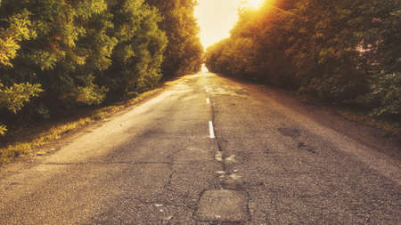 Cinematic image of the road leaving in the distance in a haze in the morning at dawnの写真素材