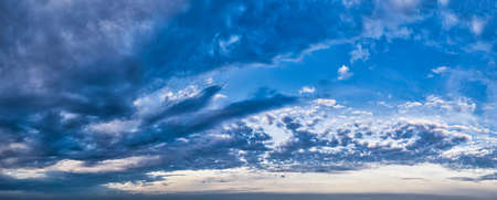 Disturbing cold blue sky with clouds - panoramic wide shotの写真素材